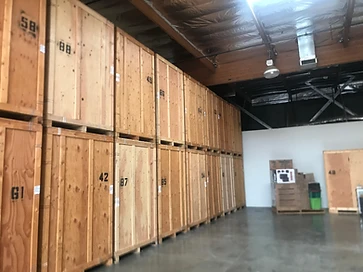 Numbered wooden storage crates stacked two-high inside a warehouse