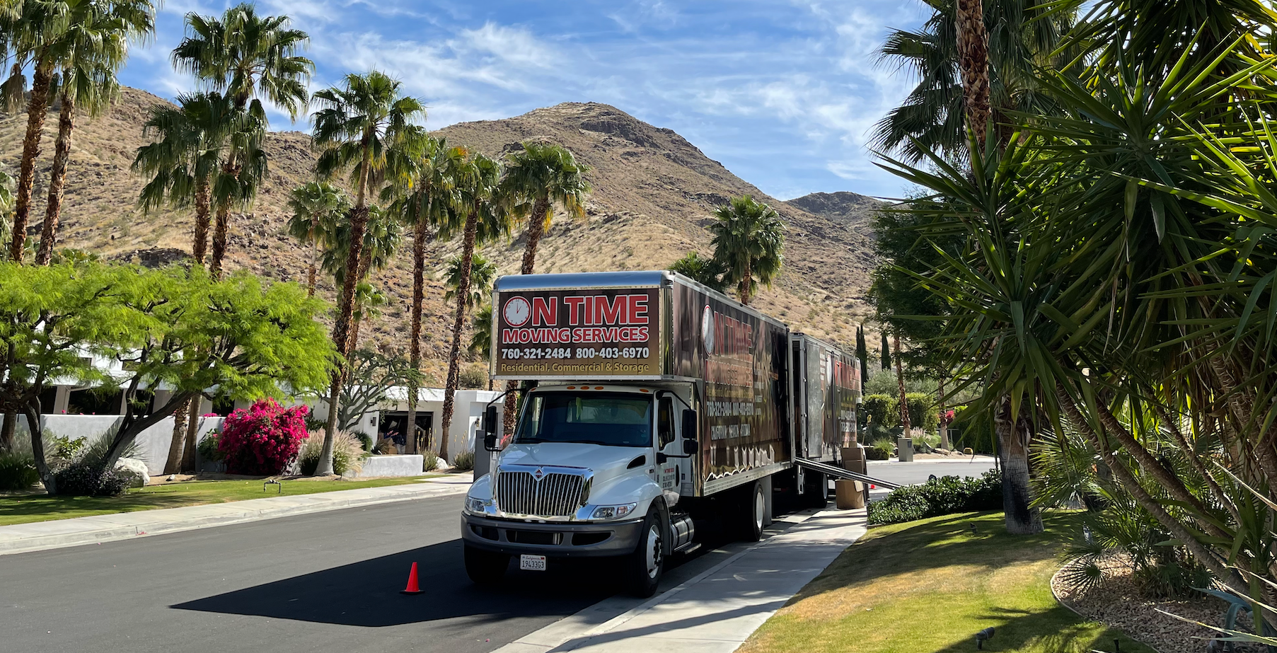 On Time Moving Services truck parked on a residential street lined with palm trees