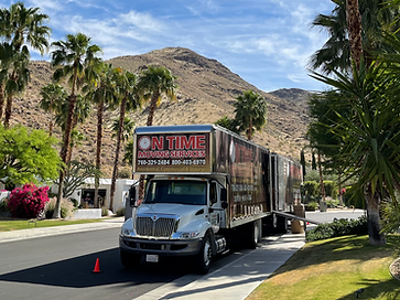 On Time Moving Services truck parked on a residential street lined with palm trees