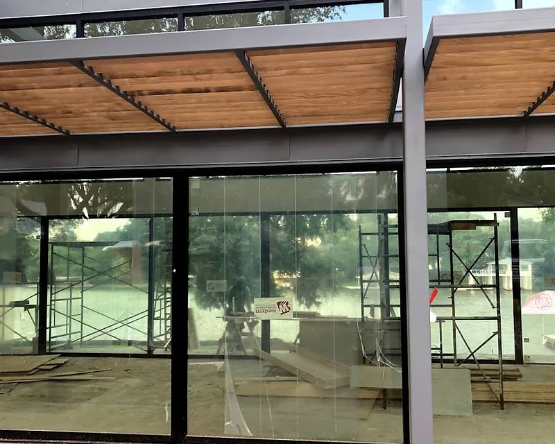 Luxury residential build with floor-to-ceiling glass and a wood canopy