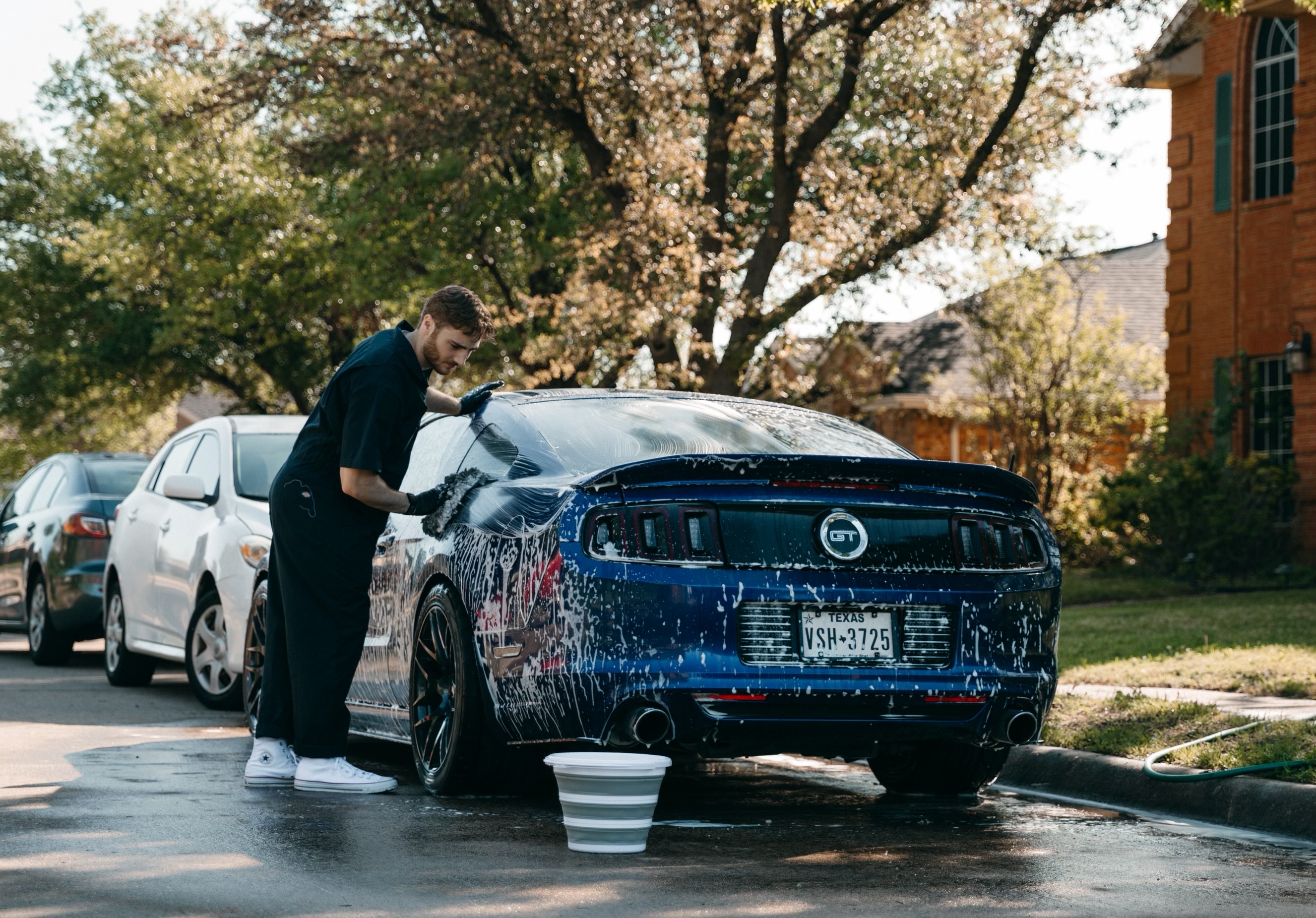 Duke Detailing washing a vehicle in a West Plano driveway