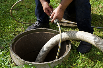 Technician feeding a jetting hose into a drain basin
