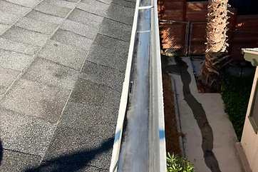 Freshly cleaned white gutter run viewed from the roof