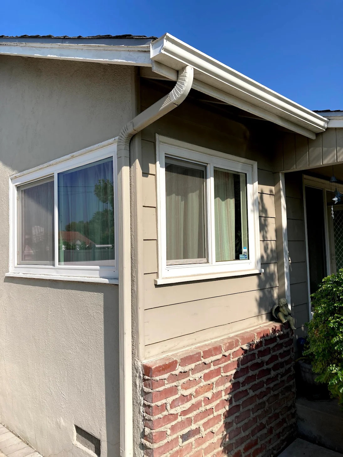 White gutter and downspout on a stucco home