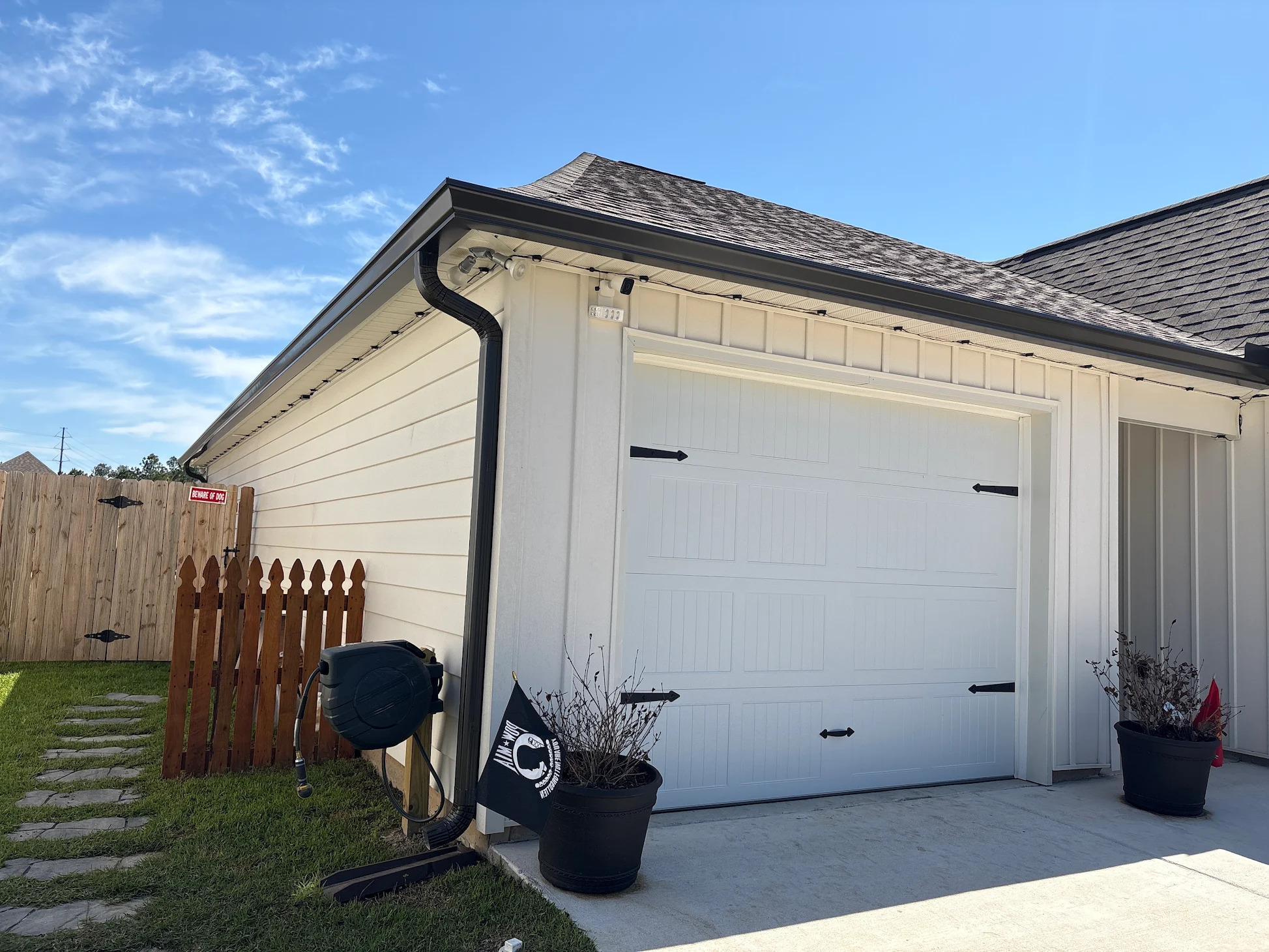 Black gutter and downspout on a white garage