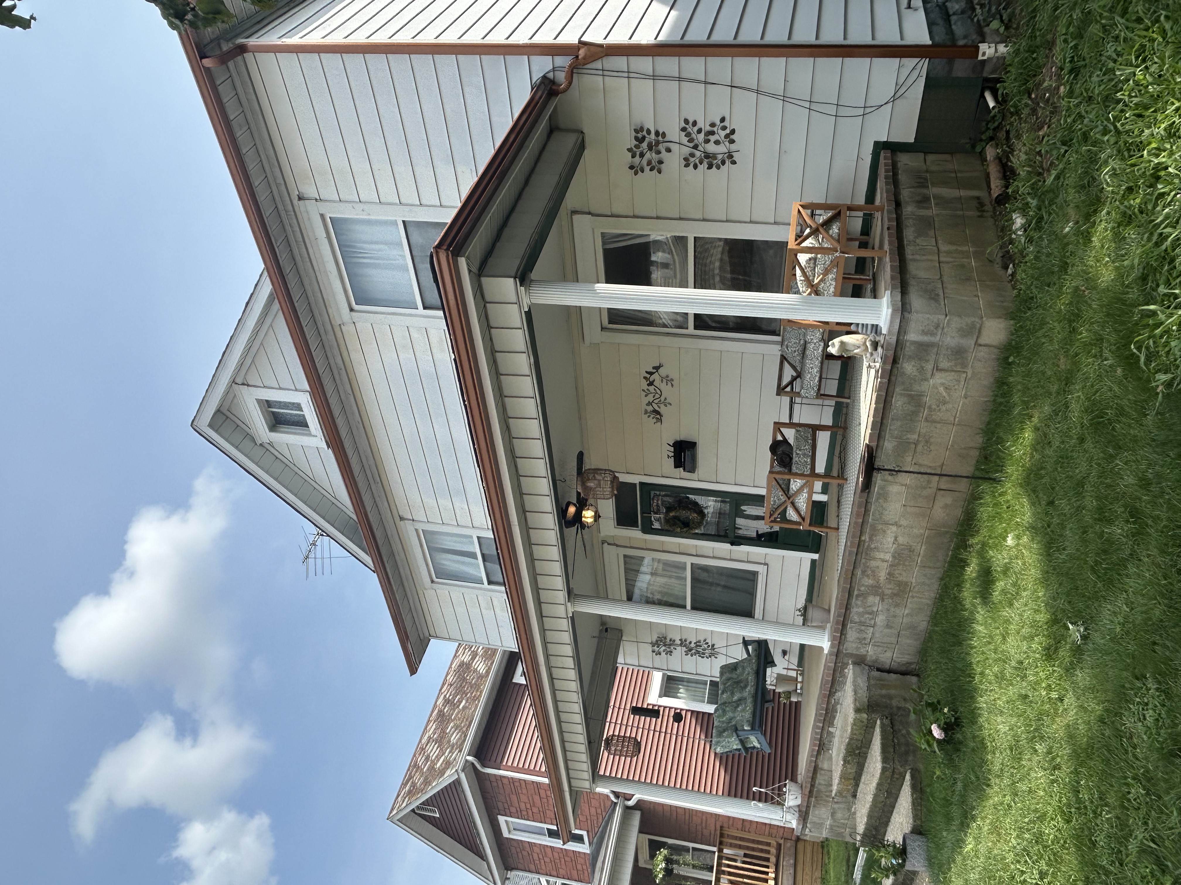 Copper-tone seamless gutters on a two-story home with front porch