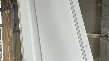 Freshly painted white cabinet door held for inspection Indiana