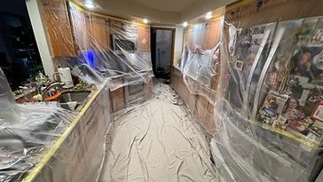 Kitchen cabinets and appliances wrapped in plastic sheeting Indiana