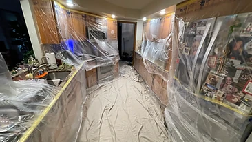 Kitchen cabinets and appliances wrapped in plastic sheeting Indiana