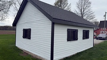 Wooden shed painted white with black trim after exterior painting Indiana