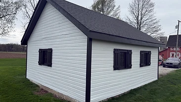Wooden shed painted white with black trim after exterior painting Indiana