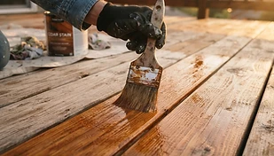 Close detail of a deck board being refinished after repair, warm cedar tone