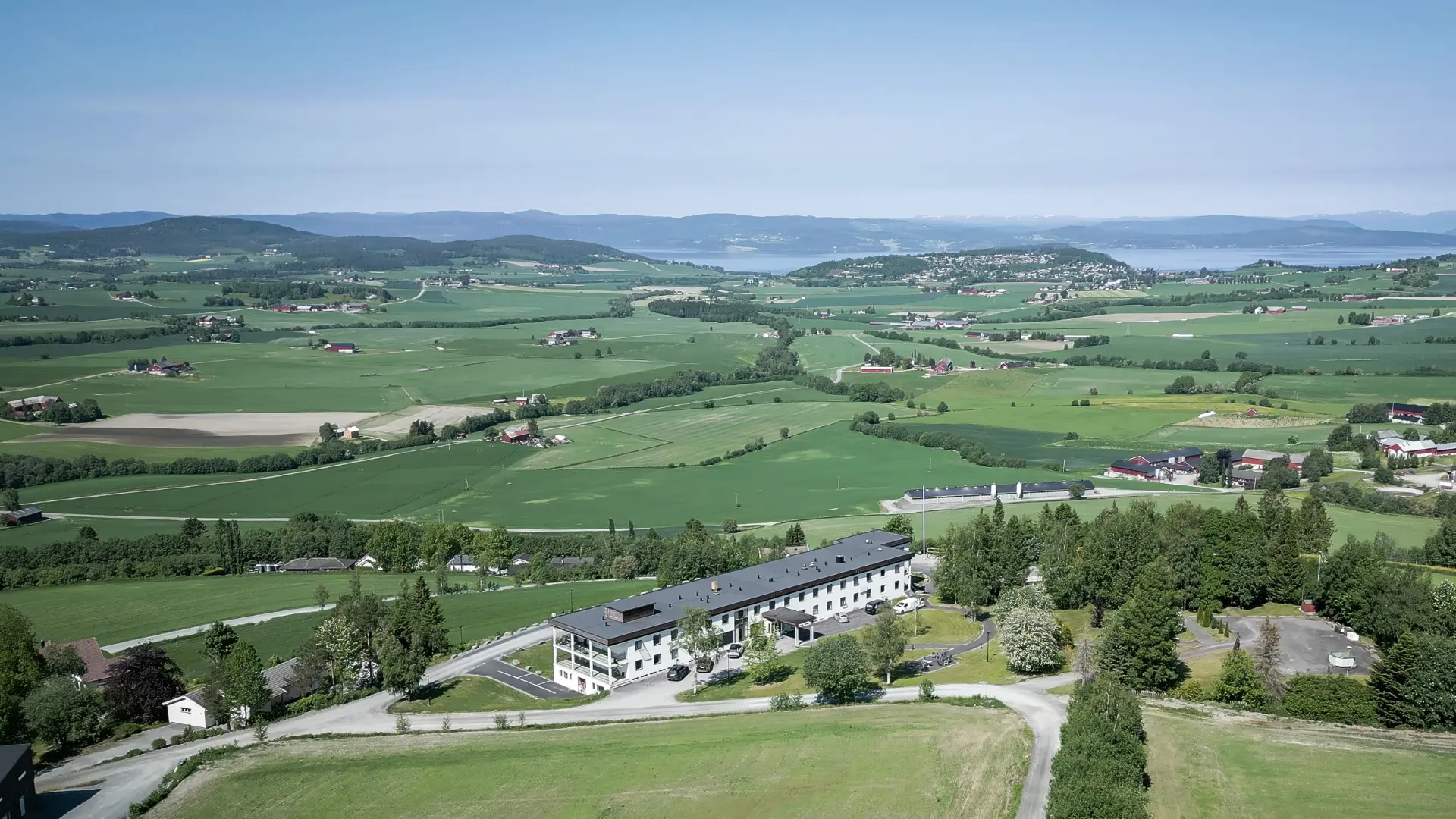 Bjørnang sett fra luften, grønne åkre og fjordlandskap