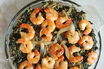 Authentic bowl of Cameroonian Ndolé — bitter leaves and ground peanut stew with shrimp, peanuts and lime