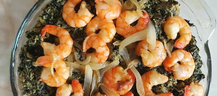 Authentic bowl of Cameroonian Ndolé — bitter leaves and ground peanut stew with shrimp, peanuts and lime