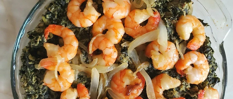 Authentic Cameroonian Ndolé — bitterleaf and peanut stew topped with shrimp and sautéed onion, served with boiled ripe plantains
