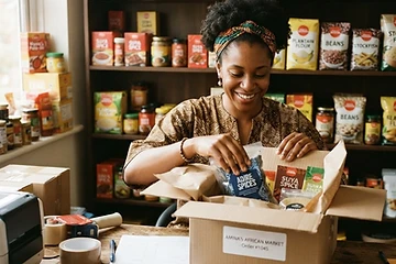 A vendor packaging African grocery products for an online order