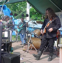 Full band performing on the outdoor stage with bass, guitar, drums and vocals at JescoFest 2006