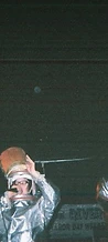 8-BIT performing on stage in silver fire suits under red spotlights at JescoFest 2006