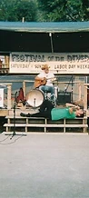 Musician on a stool and a performer lying on the stage at JescoFest 2006