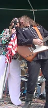 Frontman with boa constrictor and guitarist sharing a mic on the Sunday stage at JescoFest 2006