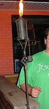 JescoFest staff member holding a lit tiki torch by a brick wall