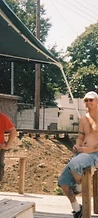 Two men posing on a wooden deck under a green canopy at JescoFest 2006