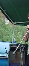 Vocalist singing into a microphone under the green canopy at JescoFest 2006
