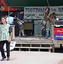 Live band performing on the outdoor stage with Festival of the Rivers banner at JescoFest 2006