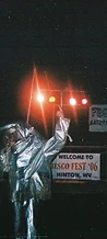 8-BIT performer in a silver fire suit pointing upward on stage at JescoFest 2006