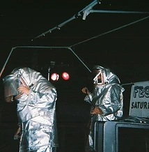 8-BIT performing on stage in silver fire suits under red stage lights at JescoFest 2006