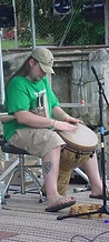 Percussionist playing a carved djembe on the Sunday stage at JescoFest 2006