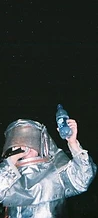 8-BIT performer in a silver fire suit holding a water bottle on stage at JescoFest 2006