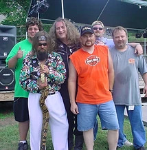 Six men posing together in front of the Festival of the Rivers stage at JescoFest 2006