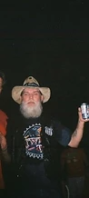 Man in an AC/DC shirt and a bearded cowboy posing together at night at JescoFest 2006