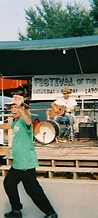 Performer dancing with arms outstretched on the wooden stage at JescoFest 2006