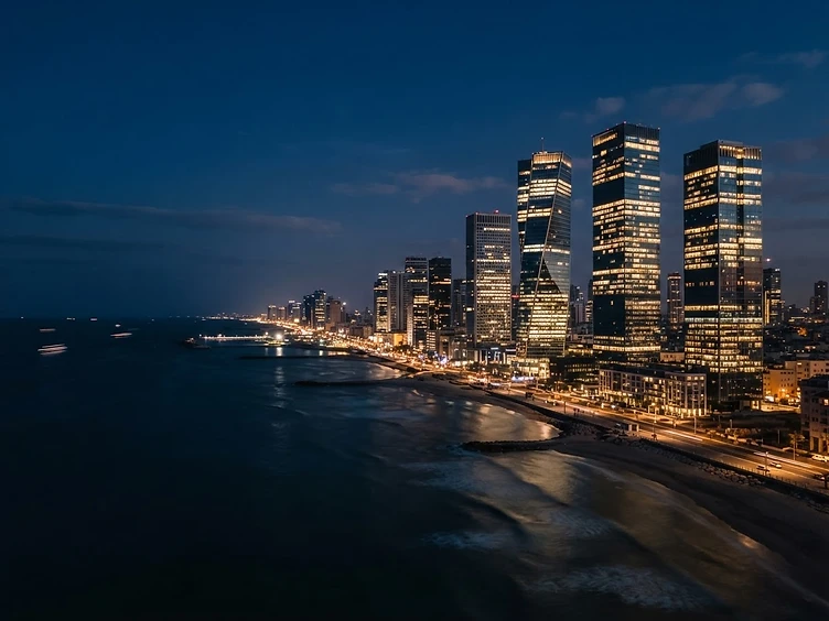 Tel Aviv technology skyline at night — modern glass towers overlooking the Mediterranean