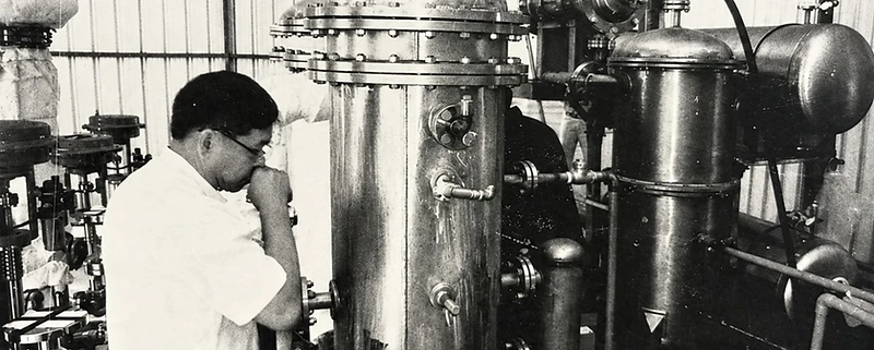 Technician inspecting stainless steel pressure vessels in a workshop