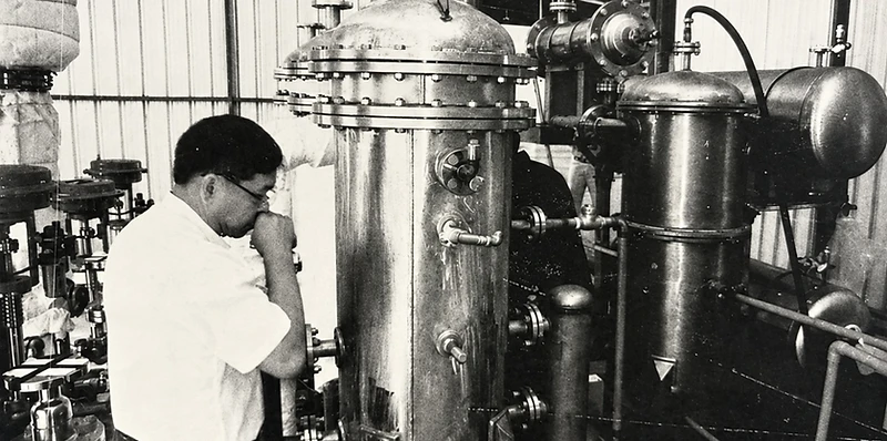 Technician inspecting stainless steel pressure vessels in a workshop
