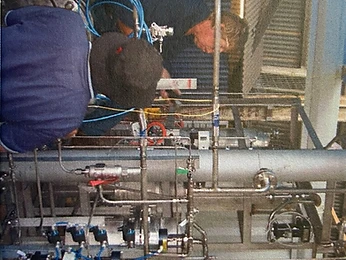 Two workers commissioning dense piping and pressure vessels