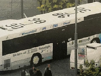 White passenger bus fitted with our system, parked on a street