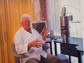 Engineer in a lab coat beside a stainless filter unit with pressure gauge