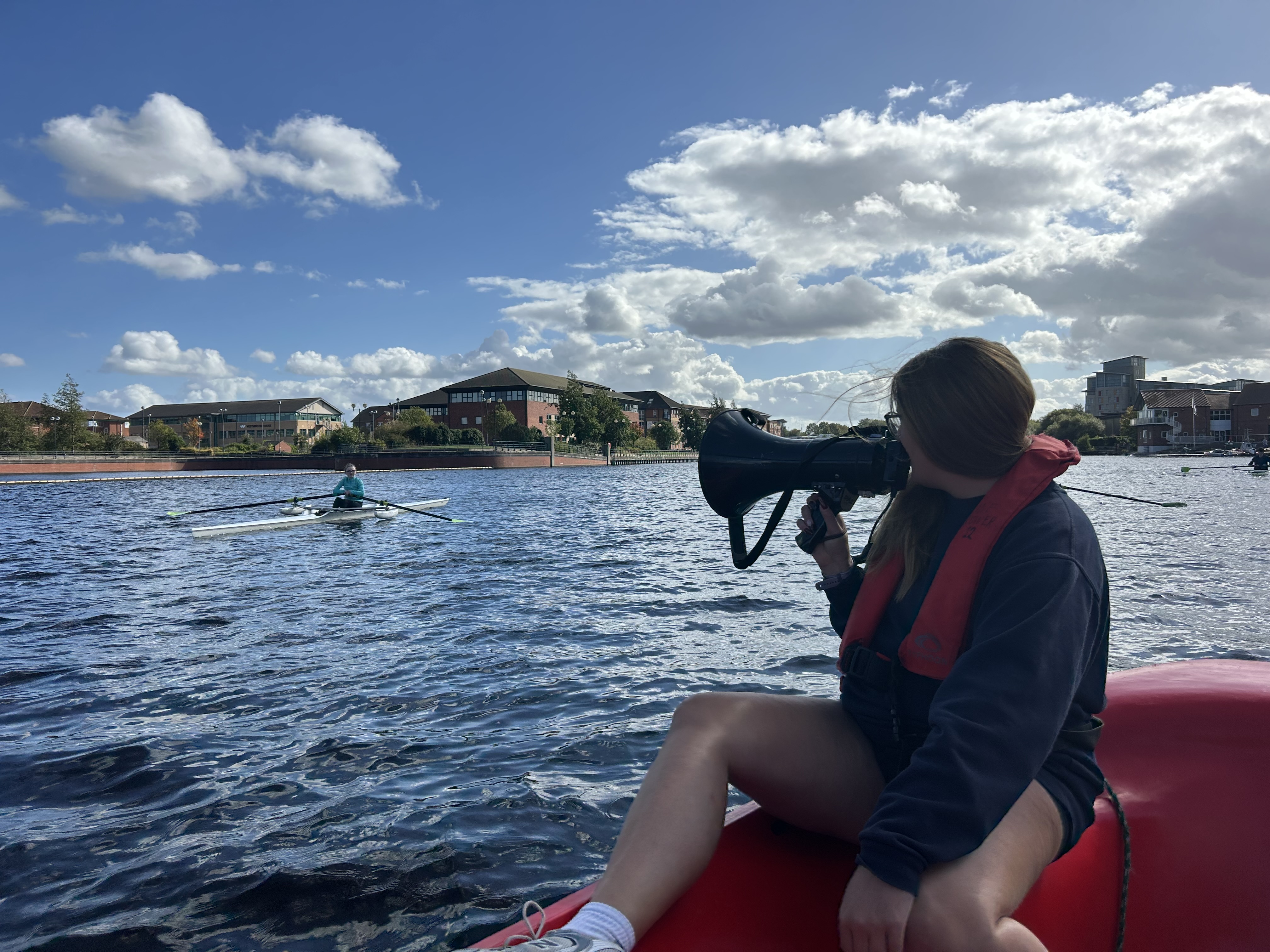 Coach guiding a young rower on the water