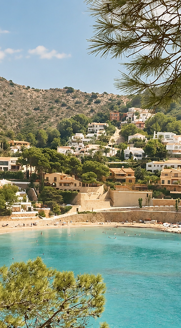 Turquoise baai met witte huizen en pijnbomen aan de Costa Blanca