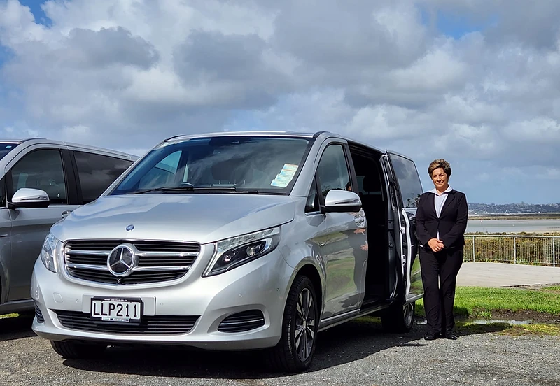 Tania Jeffs, founder of YourNZDriver, standing alongside her premium Mercedes-Benz vehicle