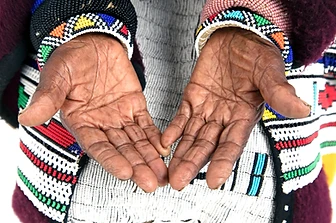 Close-up of Esther Mahlangu's hands with beaded cuffs, by Clint Strydom