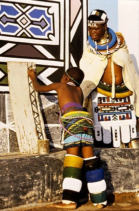 Esther Mahlangu watching a young student paint on canvas, c. 1992