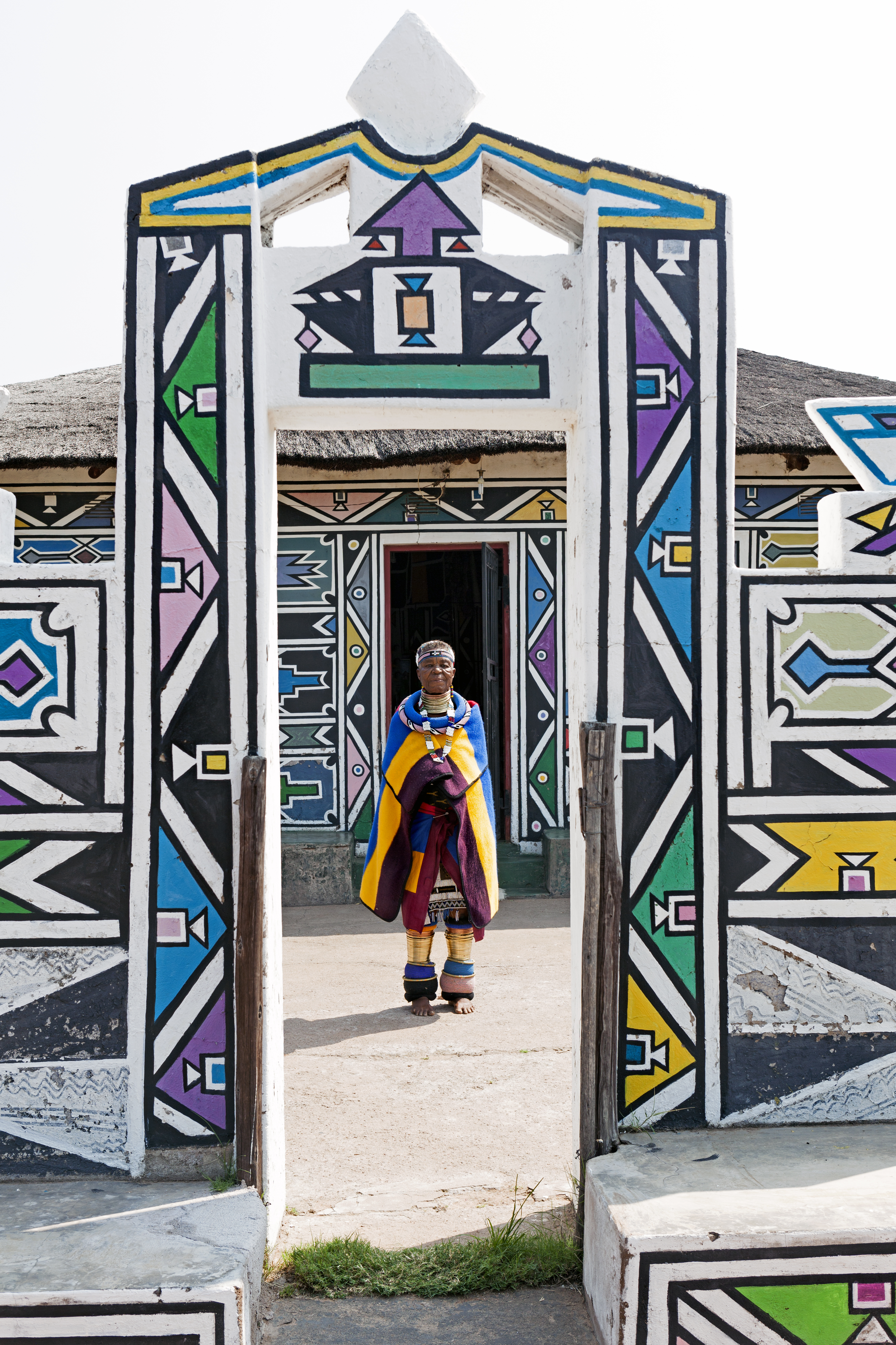 Full-length portrait of Dr Esther Mahlangu in an Ndebele doorway, by Clint Strydom
