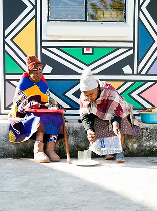 Two women on a step, one pouring water, by Clint Strydom