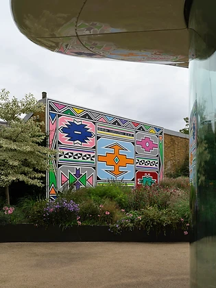 Outdoor Ndebele mural panel in a garden setting